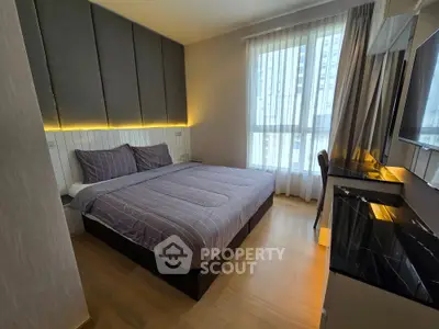 Modern bedroom with stylish decor and large window offering natural light.