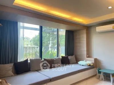 Modern living room with large windows and cozy seating area