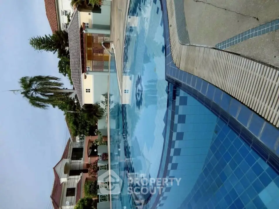 Luxurious residential pool area with pristine blue tiles and elegant surroundings.
