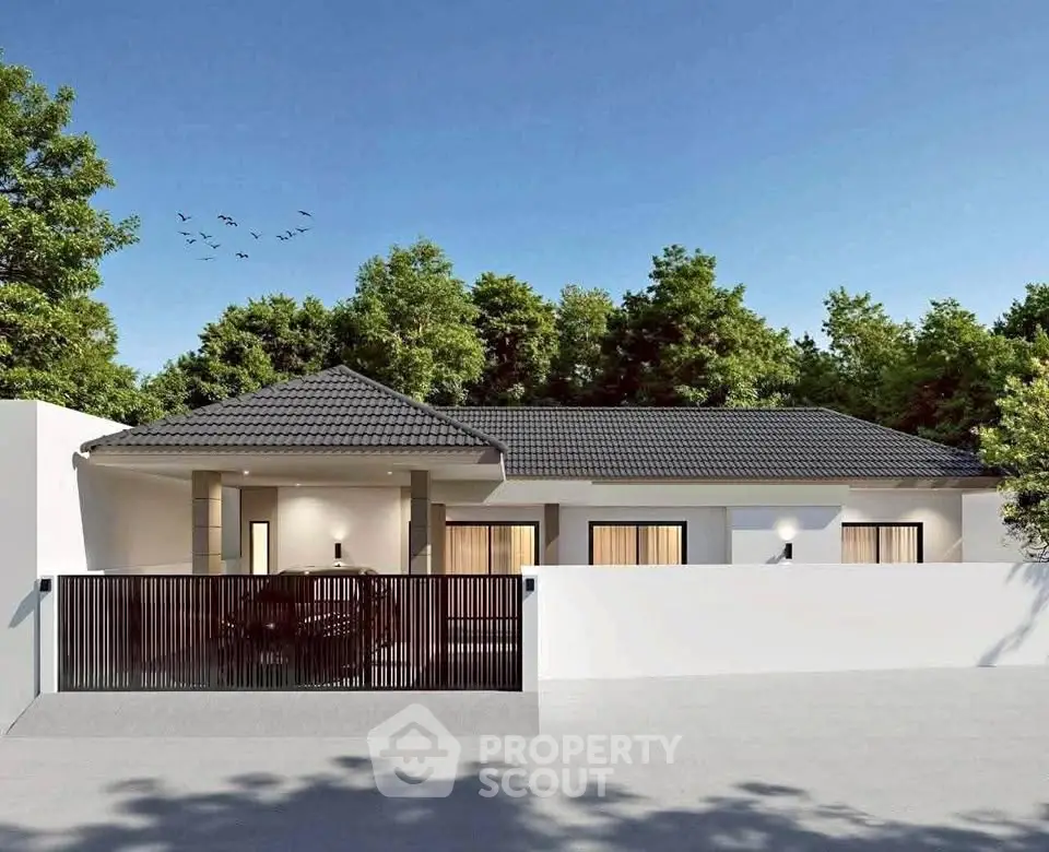 Modern single-story house with sleek design and gated entrance, surrounded by lush greenery.