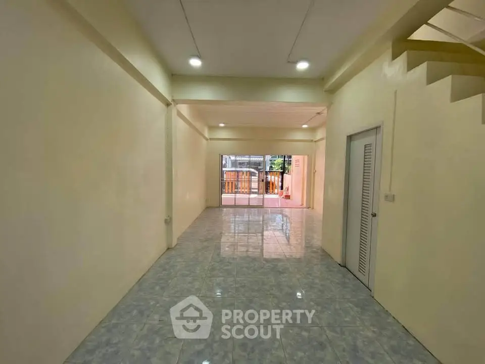 Spacious open-plan interior with tiled flooring and natural light