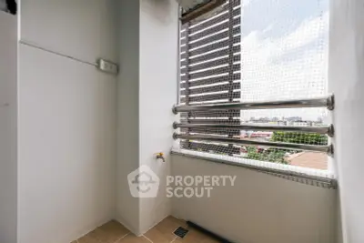 Compact balcony with safety netting and city view, ideal for small outdoor setup.