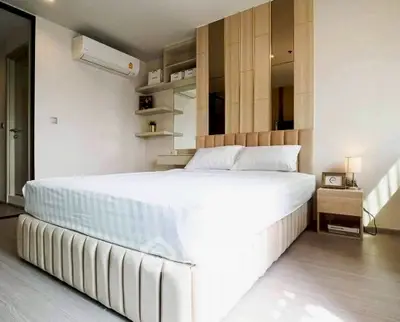 Modern bedroom with stylish decor and natural light, featuring a comfortable bed and sleek design.
