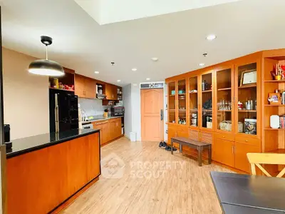 Spacious kitchen with wooden cabinets and modern appliances in a cozy apartment.