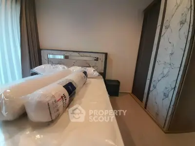 Modern bedroom with marble accents and new bedding in a stylish apartment.