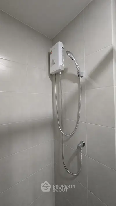Modern bathroom with sleek shower unit and tiled walls, perfect for a contemporary home.