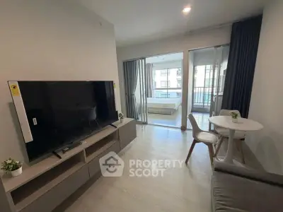 Modern living room with TV and dining area leading to a balcony view.