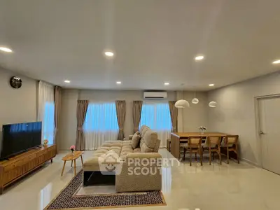 Spacious modern living room with elegant dining area and cozy seating, perfect for family gatherings.