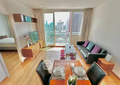 Modern living room with city view, stylish furniture, and open dining area in a high-rise apartment.