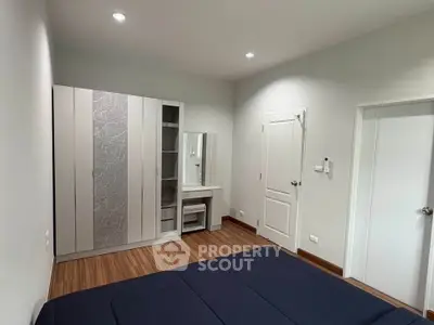 Spacious bedroom with modern wardrobe and vanity in a minimalist design.