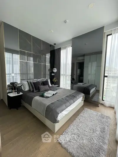 Luxurious modern bedroom with stylish decor and large windows offering natural light.