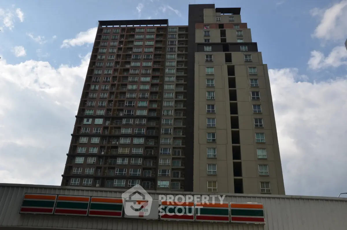 Modern high-rise building with retail store below, showcasing urban living convenience.
