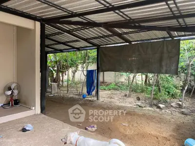 Spacious covered outdoor area with garden view and potential for customization.