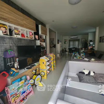 Spacious living room with modern decor and ample natural light, featuring a cozy play area for children.