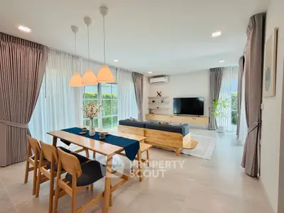 Modern living room with stylish furniture and large windows offering natural light.