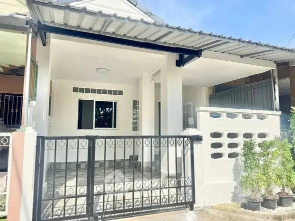 Charming single-story home with gated entrance and covered porch, perfect for cozy living.