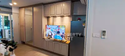 Modern living room with built-in cabinets and sleek TV setup in a stylish apartment.
