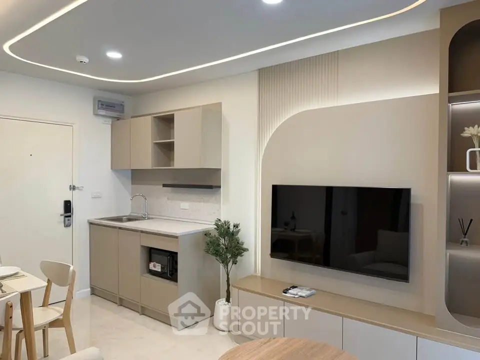 Modern living room with sleek kitchen and stylish decor in a contemporary apartment.