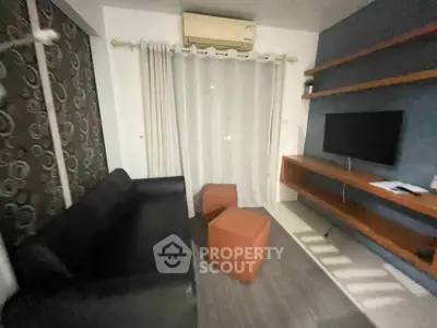 Cozy living room with modern furniture and wall-mounted TV, perfect for relaxation.