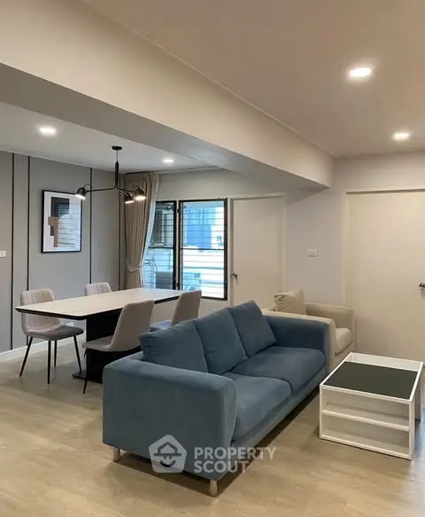 Modern living room with stylish furniture and open dining area, perfect for urban living.
