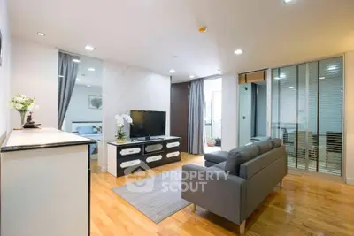 Modern living room with sleek furniture and wooden flooring in a stylish apartment.