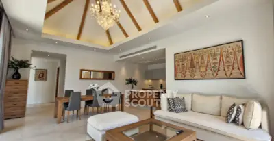 Luxurious open-plan living room with high ceilings and elegant chandelier in modern apartment.