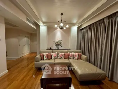 Elegant living room with plush sectional sofa and floral accents, perfect for cozy gatherings.