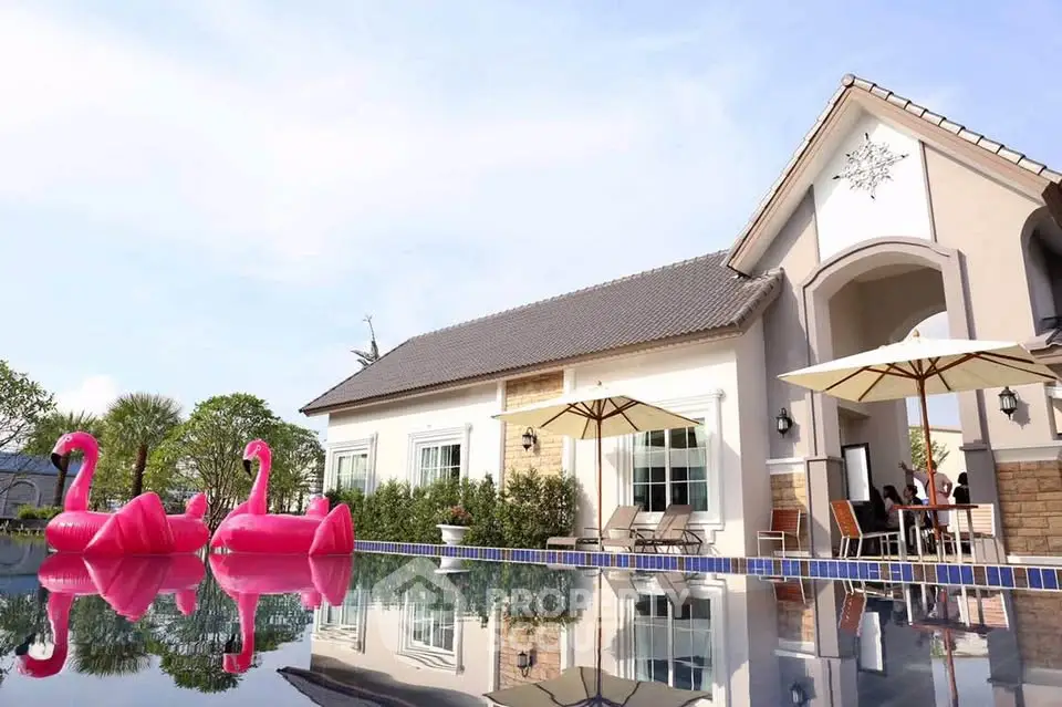 Luxurious villa with pool and flamingo floats, perfect for relaxation and entertainment.