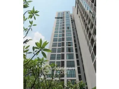 Stunning high-rise building with modern architecture and lush greenery, perfect for urban living.