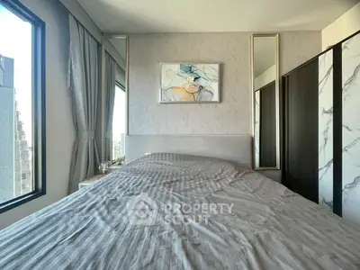 Modern bedroom with large windows and stylish decor in urban apartment.