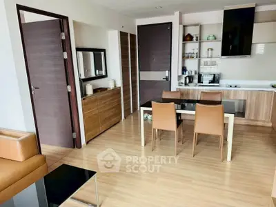 Modern open-layout kitchen and dining area with sleek wooden finishes and contemporary furniture.