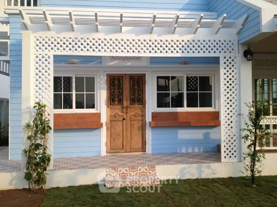 Charming blue house exterior with decorative lattice and wooden door