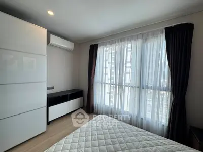 Modern bedroom with large window and sleek furniture in urban apartment