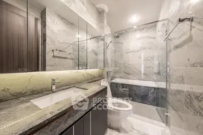 Luxurious marble bathroom with glass shower and modern fixtures