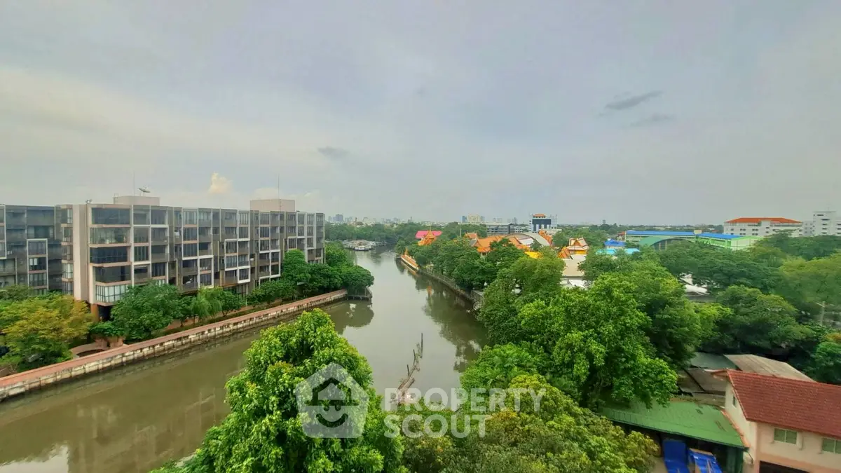 Scenic river view from a high-rise building with lush greenery and cityscape.