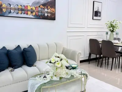Elegant living room with plush sofa and stylish dining area, perfect for modern living.