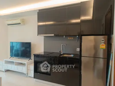 Modern kitchen with sleek black cabinets and stainless steel appliances in a stylish apartment.