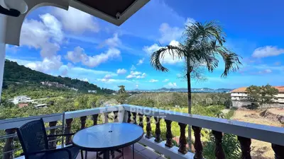 Stunning balcony view with lush greenery and distant ocean horizon