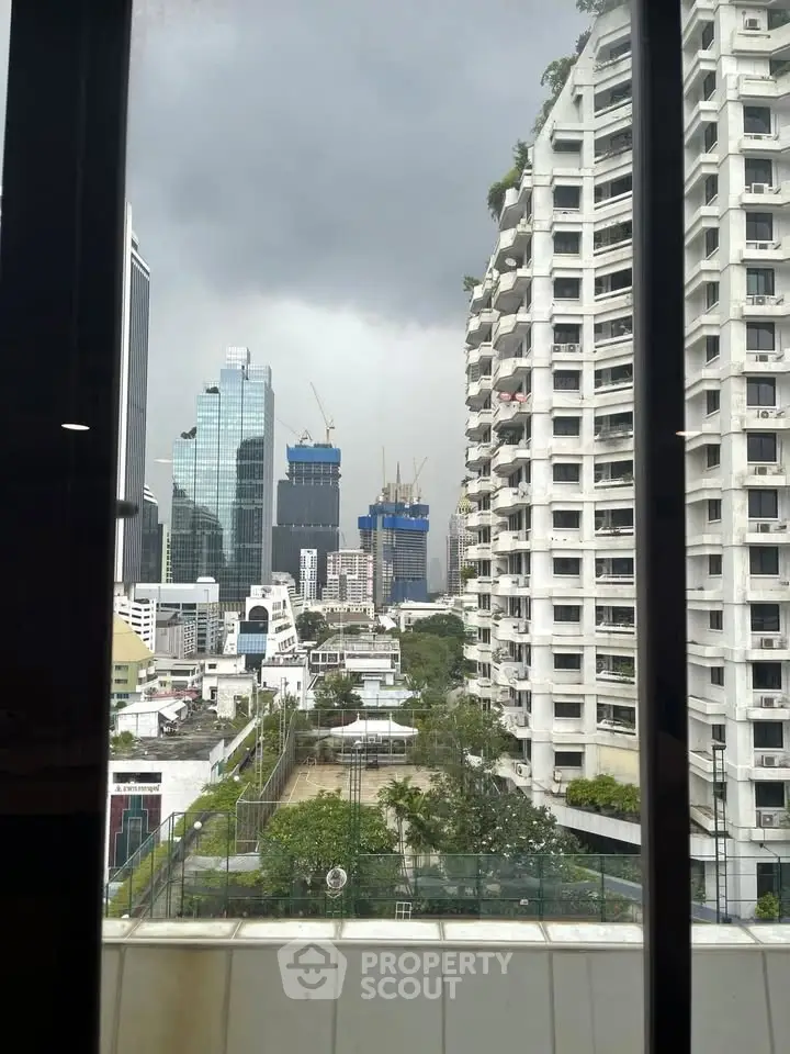 Stunning cityscape view from a high-rise building window showcasing urban skyline and modern architecture.