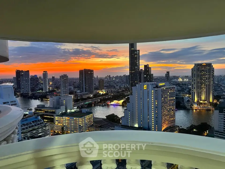 Stunning cityscape view from a high-rise balcony at sunset, showcasing vibrant skyline and river.