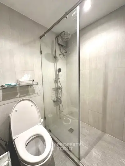 Modern bathroom with glass shower enclosure and sleek fixtures.