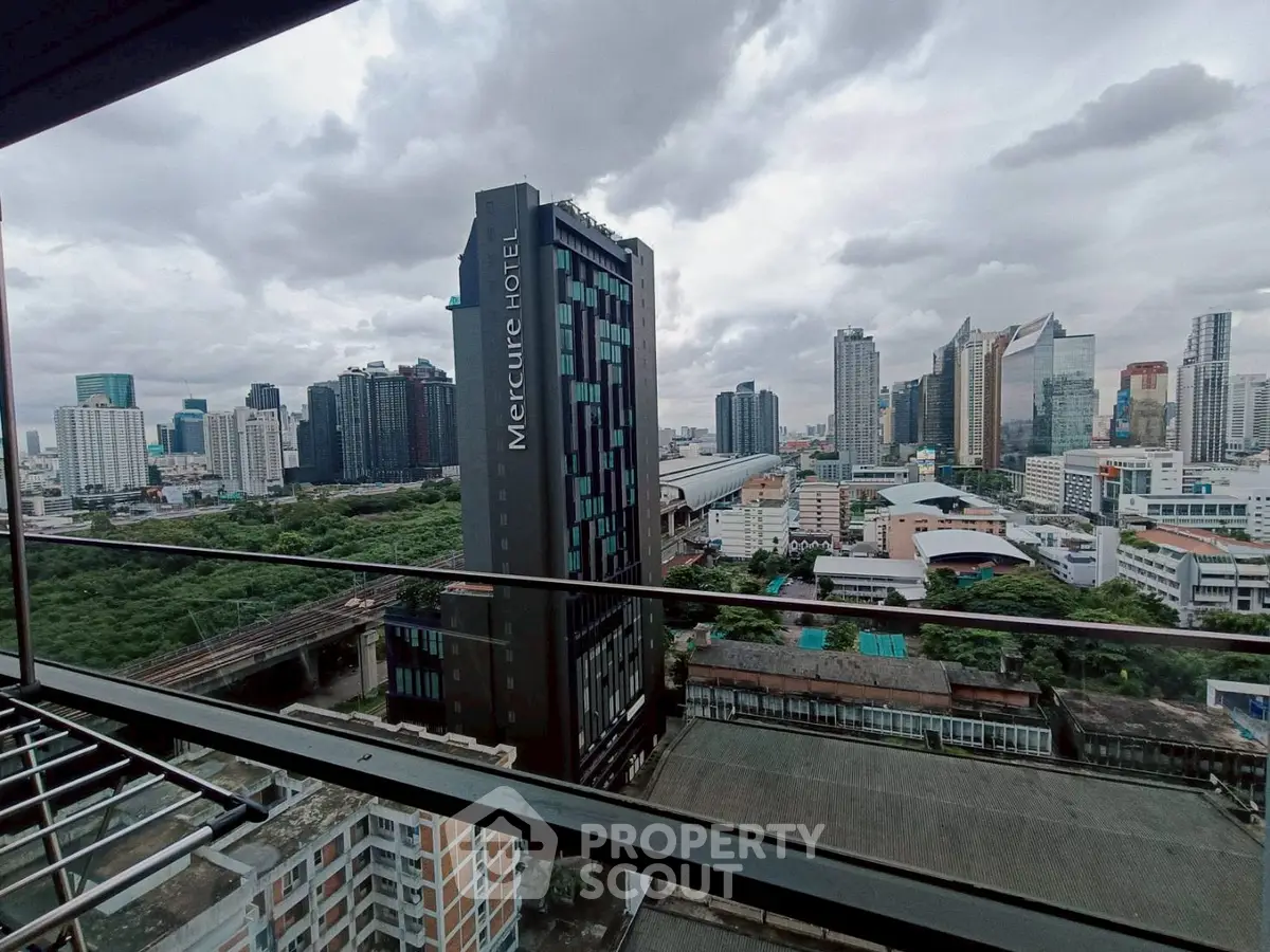 Stunning cityscape view from a high-rise balcony overlooking modern skyscrapers and lush greenery.
