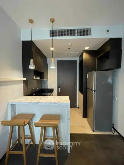 Modern kitchen with marble countertop and bar stools in sleek apartment