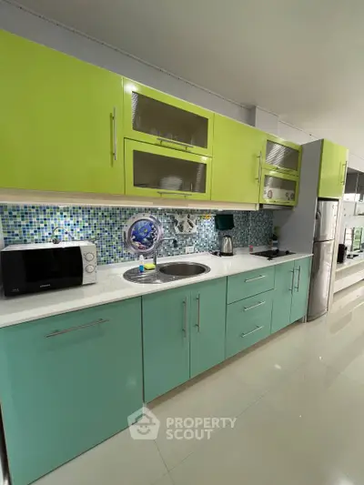 Modern kitchen with vibrant cabinetry and sleek appliances