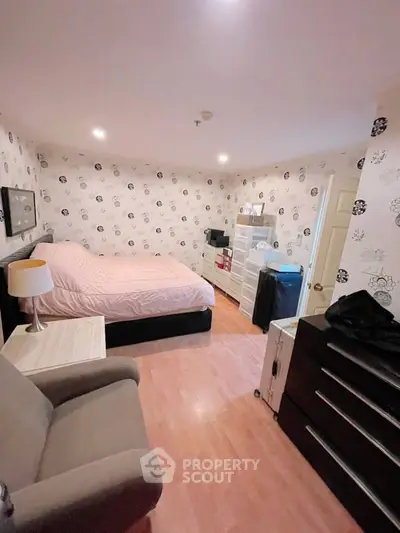 Cozy bedroom with modern decor and ample storage space, featuring stylish wallpaper and comfortable furnishings.