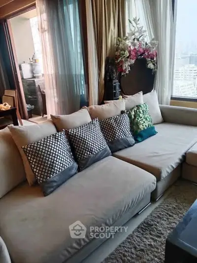Luxurious living room with plush sofa and city view, perfect for relaxation and entertaining.
