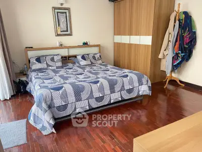 Spacious bedroom with wooden flooring and modern decor