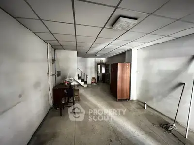 Spacious interior with minimal furniture and staircase, ideal for customization.