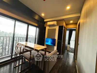 Modern living room with city view, sleek furniture, and large windows in high-rise apartment.