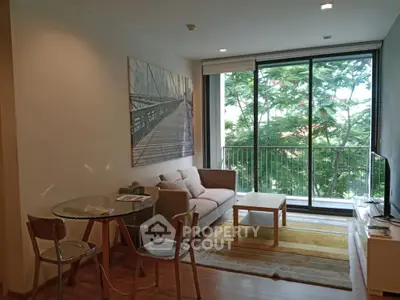 Charming living room with cozy seating and lush green view from balcony.